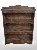 A 20th century oriental heavily carved beech open bookcase,