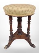 A late-Victorian mahogany adjustable stool on tripod legs,