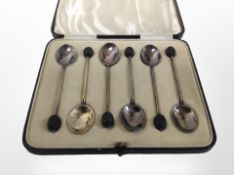 A cased set of six silver coffee spoons with enamelled decoration to the reverse.