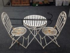 A painted wrought metal circular garden table,