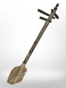 An Eastern three-stringed instrument, length 63cm.