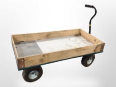 A four-wheel flat bed goods trolley, length 121cm.