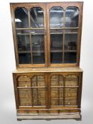 A Victorian mahogany bookcase fitted a bank of 12 fall-front drawers and three further slim drawers