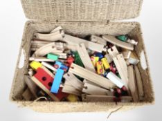 A wicker hamper containing Brio railway track and trains.