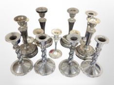 A group of chrome and silver-plated candlesticks.
