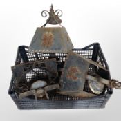 A group of weathered wrought-metal hanging light shades.