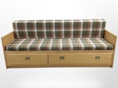 A 20th century Danish oak sofa bed with checked cushions,
