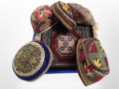 A small Iranian mat, together with five Eastern traditional hats,