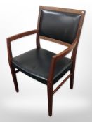 A 20th-century Danish teak and black vinyl armchair.