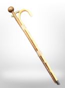 A brass-handled walking stick, a further walking stick, and an African chief's-style hardwood staff.