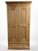 A contemporary pine double-door wardrobe, 102cm wide x 55cm deep x 200cm high.