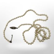 A single-stand pearl necklace with white gold diamond-set clasp,