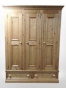 A contemporary pine triple-door wardrobe, 149cm wide x 55cm deep x 200cm high.