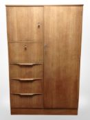 A 20th-century teak compactum wardrobe, 98cm wide x 45cm deep x 152cm high.