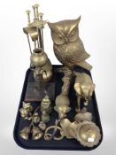 A group of brass items including figure of an owl perched on branch, fire companion set,
