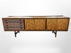 A 20th century teak low sideboard, fitted with cupboards and drawers,