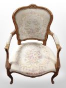 A continental carved beech salon armchair in floral embroidered upholstery, width 62cm.