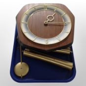 A continental teak wall clock with brass weights and pendulum.