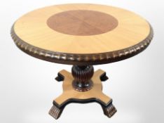 A reproduction circular occasional table on paw feet, diameter 84cm.