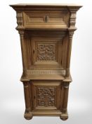 A reproduction continental heavily carved oak pillar cabinet, 65cm wide x 48cm deep x 148cm high.
