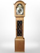 A reproduction oak tempus fugit longcase clock, with pendulum and weights, height 195cm.