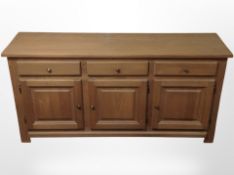 An oak veneered sideboard fitted cupboards and drawers, 176cm wide x 48cm deep x 87cm high.