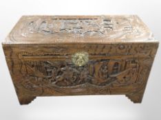 An oriental heavily carved camphor wood box, 101cm wide x 50cm deep x 58cm high.
