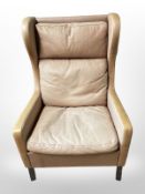 A Danish tan leather wing armchair, width 69cm. CONDITION REPORT: Faded.