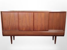 A 20th-century Danish teak sliding-door sideboard raised on tapered legs,