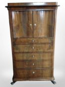 A 19th-century continental walnut serpentine-front chest fitted cupboard doors and five drawers