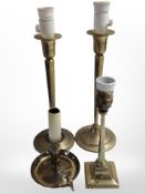 A pair of brass candlesticks converted to table lamps, height 41cm, together with two further lamps.