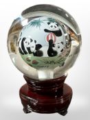 A Chinese reverse-painted glass globe ornaments depicting pandas on wooden stand, height 15.