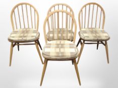 A set of four Ercol elm and beech spindle back dining chairs with seat pads.