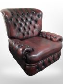 An oxblood buttoned leather Chesterfield armchair, width 98cm.