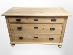 An early-20th century continental pine three-drawer chest on bun feet,