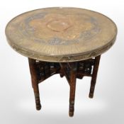 An Indian bobbin turned occasional table with embossed brass top, diameter 60cm.