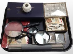 A group of magnifying glasses, spools of thread, picture frames, loose stamps, etc.