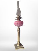 A brass and opaque glass oil lamp. CONDITION REPORT: Crack to reservoir.