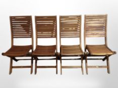 A set of four teak folding garden chairs.