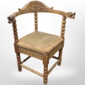 A continental heavily carved pine corner armchair.