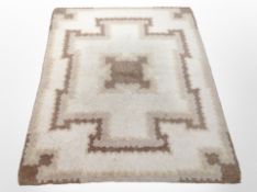 A 1970s woolen rug on beige ground, 148cm x 115cm.
