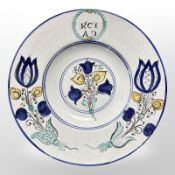 A Delft tin-glazed charger copying an 18th-century example, diameter 31.5cm.