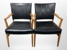 A set of seven oak-framed armchairs, upholstered in brass-studded black leather.