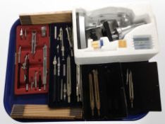 A group of precision drawing instruments, folding rulers, microscope.