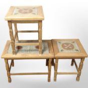 A group of three Danish blonde oak tile-topped occasional tables, largest 61cm wide.