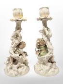 A pair of continental figural pottery candlesticks, height 23cm.