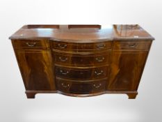 A reproduction mahogany bow-front sideboard, 132cm wide x 44cm deep x 80cm high.