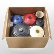 A group of Le Creuset and other enamelled cast-iron cooking pans.