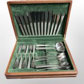 A teak canteen of Viners stainless steel cutlery with textured handles.