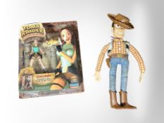 A Playmates Toys Lara Croft Tomb Raider figurine, in packaging, and a Toy Story Woody figure.